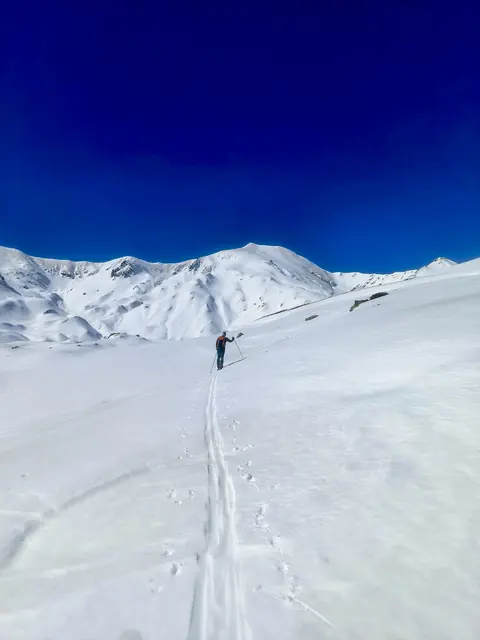 Persona practicant esquí de muntanya a la Vall Fosca en un paisatge d'alta muntanya cobert de neu.